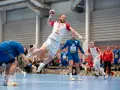 Gracz w białej koszulce z numerem 28 wyskakuje do rzutu podczas meczu polska Serbia piłka ręczna.