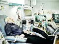 Starszy mężczyzna leży na fotelu dializacyjnym obok aparatury medycznej.