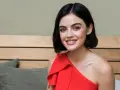 Lucy Hale sorride con un vestito rosso, ricordando i suoi film e programmi TV.