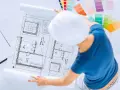 Pracownia znanych projektantów wnętrz: szkice planów, palety kolorów i biały kask.