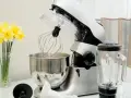 Robot planetarny z akcesoriami i blenderem, gotowy do przygotowania ciast, kremów i koktajli. Wiosenne żonkile dodają uroku.