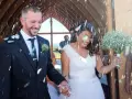 Szczęśliwa para młoda wychodzi z kościoła, obsypana płatkami. To śmieszna niespodzianka dla pary młodej, która na pewno zapamięta ten dzień.