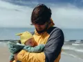 Ojciec z dzieckiem na plaży. Zastanawia się, ile trwa urlop tacierzyński, ciesząc się wspólnym czasem.