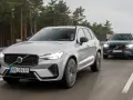 Dwa Volvo XC60 T8 jadące po drodze leśnej. Jeden srebrny, drugi ciemnoszary.