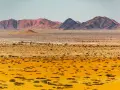 Pustynny krajobraz Namibii z górami w tle. Idealny czas na podróż do Namibii to okres od maja do października, kiedy jest sucho i chłodniej.