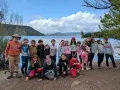 Un animateur pour combien de jeunes ? Un groupe d'enfants souriants pose devant un lac, prêts pour l'aventure.