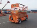 Pomarańczowa podnośnik nożycowy JLG 4069LE, znany jako UTB, stoi na placu. To sprzęt budowlany.
