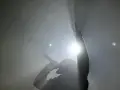Un rappeur, micro en main, lève un doigt en signe de paix. Lumière intense, fumée, ambiance d'un exposé sur le rap.