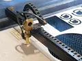 Macchina laser che sta per tagliare compensato, creando forme precise.