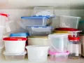 Stos pojemników na żywność, niektóre z kolorowymi pokrywkami. Uważaj na ftalany w plastiku.
