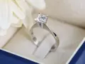 Anello con diamante in un cofanetto blu. La brillantezza del diamante, misurata in carati, cattura la luce.