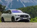Biały Mercedes GLE 53 AMG coupe na tle górskiego krajobrazu z lasem.