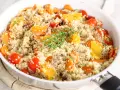 Salade de quinoa colorée avec carottes, tomates cerises et quartiers d'orange, garnie de thym. Un plat savoureux qui met en avant les quinoa bienfaits.
