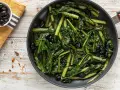Verdura di catalogna saltata in padella con olive nere. Un piatto semplice e gustoso, pronto per essere servito.