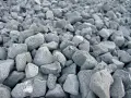 En stor hög med grå, porösa stenar. Skumglas nackdelar kan vara att materialet är lätt och kan blåsa iväg.