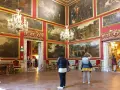 Wnętrze Galerii Doria Pamphilj z obrazami i żyrandolami.