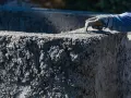 Ręka w rękawicy wygładza świeży beton. Zastanawiasz się, ile kosztuje worek cementu, by stworzyć coś takiego?