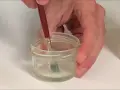 Pincel sumergido en un frasco con disolvente oleo, listo para limpiar.