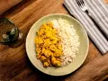 Plato de arroz con pollo en salsa curry, acompañado de arroz blanco. Un delicioso arroz con verduras y proteína.