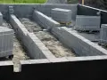 Budowa fundamentów z bloczków betonowych, przygotowanie pod izolację pionową fundamentów.