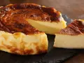 Pyszny, lekko przypieczony sernik na czarnej desce. Nawet jeśli sernik kcal kusi, warto spróbować!