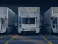 Drei weiße LKWs stehen nebeneinander vor einem Gebäude. Ein LKW-Fahrverbot am Wochenende könnte hier gelten.