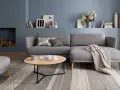 Gemütliches wohnzimmer skandinavischer stil mit grauem Sofa, Holztisch und Kamin.