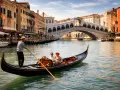 Coppia in gondola per un tour a Venezia, con il Ponte di Rialto sullo sfondo.