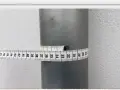 Miarka krawiecka owinięta wokół szarej rury pokazuje, jak zmierzyć średnicę rury. Odczyt wynosi około 32 cm.