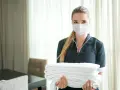 Pracownica hotelu w maseczce niesie stos czystych ręczników. Odpowiedź na pytanie: czy w hotelach są ręczniki - tak!