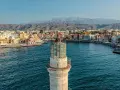 Latarnia morska wenecka w Chanii, prom na Krecie, z widokiem na port i góry w tle.