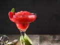 En fryst strawberry daiquiri med mynta och jordgubbsdekoration, redo att avnjutas.
