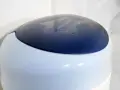 Niebieska pokrywa kosza na pampersy Tommee Tippee z wygrawerowanym logo.
