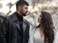 Un uomo con trench di pelle nera e una donna con lunghi capelli scuri si guardano intensamente. Io sono Farah, e questo sguardo dice tutto.