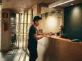 Mężczyzna melduje się w hotelu. Pracownica recepcji wyjaśnia, ile zarabiają turcy w hotelach, gdy obsługuje gościa.