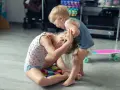Kleinkind hält älteres Kind am Kopf fest. Was tun, wenn Kinder schlagen? Hier wird spielerisch gestritten.