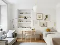 Accogliente camera da letto minimal con letto singolo, scrivania in legno, divanetto e quadri alle pareti.