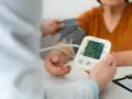 Pomiar ciśnienia krwi. Na ekranie aparatu widnieje wynik 134/77, a poniżej 78.
