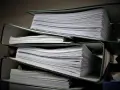 Stosy dokumentów w segregatorach, gotowe do złożenia jako list motywacyjny do urzędu.