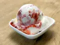 Ein Eisbecher mit Erdbeersoße, der zum sofortigen Genuss einlädt. Ein wahrer "Ed von Schleck" Moment!