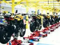 Linea di produzione MV Agusta: moto sportive gialle e nere in fase di assemblaggio su supporti rossi.