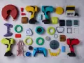 A vibrant collection of components, likely from a color resin 3D printer project, including tool-like objects, game controller parts, and various geometric shapes.