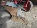 Metalowy lemiesz pługa, gotowy do pracy na polu. To właśnie on odwraca ziemię, przygotowując ją pod zasiew.