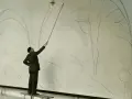 Henri Matisse, z laską w dłoni, kieruje pracami nad szkicem swojego słynnego "Tańca".
