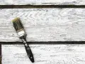 Pennello sporco su assi di legno bianco, pronto per la cementite per legno già verniciato.
