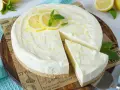 Cremige Philadelphia Torte mit Zitronenscheiben und Minze, ein Stück wurde bereits entnommen.