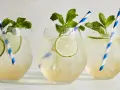 Tre svalkande Hugo Spritz med mynta och lime, perfekta för en solig dag.