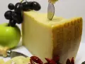 Ein Stück Parmigiano Reggiano mit Trauben, Apfel und Chilis. Verschiedene parmesan sorten sind hier schön arrangiert.