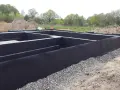 Fundament gotowy do zalania betonem. Czarna folia izolacja pozioma chroni przed wilgocią.