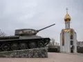 Czołg z napisem "Za Rodinu!" stoi obok cerkwi z złotą kopułą. Pomnik na nadniestrze.